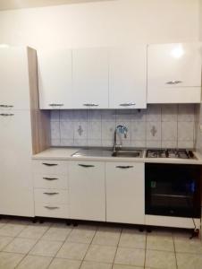 a kitchen with white cabinets and a sink at Apartments by the sea Krapanj, Sibenik - 9258 in Brodarica