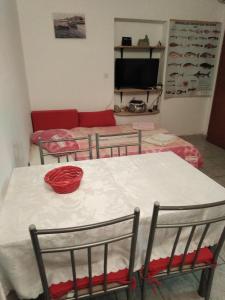 a room with a table and chairs and a couch at Apartments by the sea Krapanj, Sibenik - 9258 in Brodarica