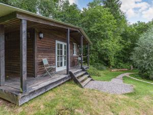 eine Holzhütte mit einer Veranda und einer Tür in der Unterkunft Lakeside Cabin in Dunkeswell