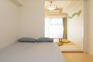 een slaapkamer met een bed en een raam bij Shinjuku-Kabukicho-507 in Tokyo
