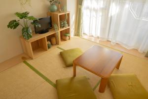een woonkamer met een tafel en stoelen en een televisie bij Shinjuku-Kabukicho-507 in Tokyo