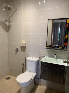 La salle de bains est pourvue de toilettes, d'un lavabo et d'un miroir. dans l'établissement Raintown Cottage, à Taiping