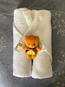 a stuffed teddy bear sitting in a towel at Raintown Cottage in Taiping