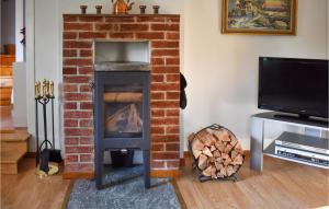 a brick fireplace with a stove in a living room at Amazing Home In Hagalund-mjlby With Wifi in Mjölby