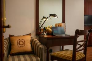 a desk with a laptop and a chair in a room at May De Ville Trendy Hotel & Spa in Hanoi