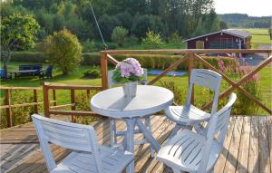 a table with two chairs and a vase of flowers on a deck at Amazing Home In Hagalundmjölby in Mjölby +16 photos
