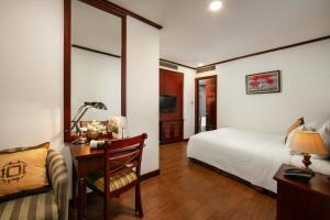a bedroom with a bed and a desk and a chair at May De Ville Trendy Hotel & Spa in Hanoi