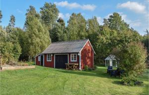 a red barn with a picnic table in a yard at Amazing Home In Hagalund-mjlby With Wifi in Mjölby