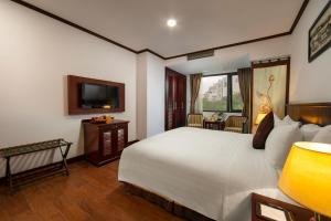 a hotel room with a bed and a television at May De Ville Trendy Hotel & Spa in Hanoi