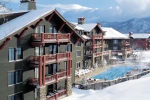a building with a swimming pool in the snow at Aspen Ritz-carlton 3 Bedroom Residence in Aspen