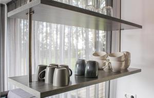 a shelf with cups and mugs in front of a window at Awesome Ship In Warns With Kitchen in Warns