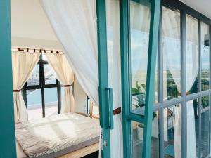 a room with a window with a bed and a balcony at LIM House in Phan Thiet