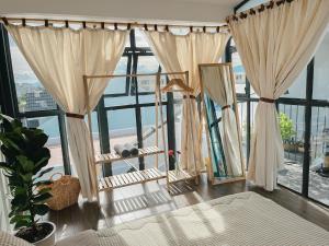 a room with a large window with curtains at LIM House in Phan Thiet