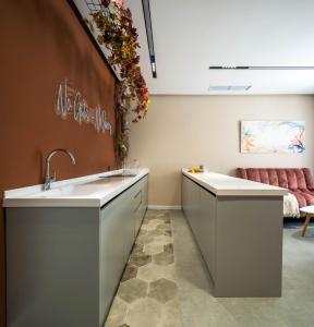 une cuisine avec deux lavabos et un canapé dans l'établissement Lazy Seal Holiday Cottages Nabran, à Müqtǝdir