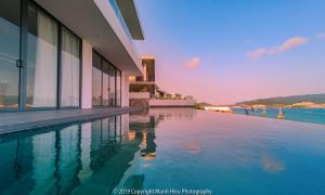 a swimming pool next to a building with the water at Casa Blanca Villas in Nha Trang