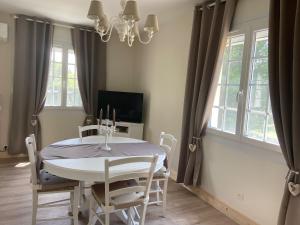 a dining room with a white table and chairs at La Petite Bonbonnière, proche du Zoo de Beauval, au calme in Billy