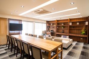 uma sala de conferências com uma grande mesa de madeira e cadeiras em Koon Hotel Sukhumvit em Bang Na
