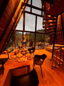 安布羅勞里的住宿－Wild Escape Racha，配有大窗户的客房内一张大木桌