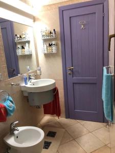 een badkamer met een wastafel en een paarse deur bij Villetta Reparata in Santa Teresa Gallura