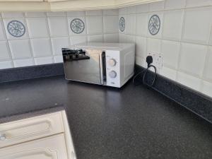 a microwave sitting on a counter in a kitchen at Contractors Home from Home in South Benfleet