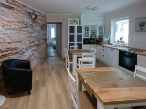 a kitchen with a brick wall and a table and chairs at Bokor vendégház - Levendula apartman in Szentes