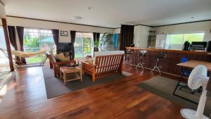 ein Wohnzimmer mit Holzböden, eine Küche und ein Wohnzimmer mit in der Unterkunft Océanos - Sunset, BBQ, Beach & Kayak - オケアノス in Ishigaki-jima