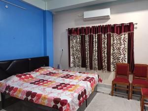 um quarto com uma cama e 2 cadeiras em Ujjayanta Homestay em Agartala