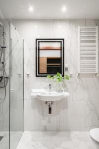 a white bathroom with a sink and a mirror at Hotel Jazz Market Square Wroclaw in Wrocław