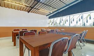 a conference room with wooden tables and chairs at Treebo Trend Sreepathi Mayoogha in Guruvāyūr