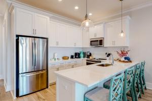 a kitchen with white cabinets and a stainless steel refrigerator at Lost Dunes #B in Gulf Shores