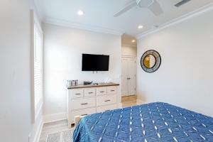 a bedroom with a bed and a tv on a wall at Lost Dunes #B in Gulf Shores