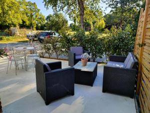 a patio with chairs and a table and a table and chairs at La Grange in Delettes
