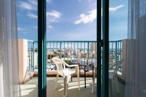balkon ze stołem i krzesłem na balkonie w obiekcie Hotel Bell Harmony Ishigaki Island w mieście Ishigaki