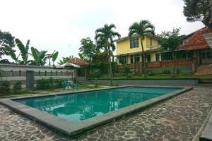- une piscine en face d'une maison dans l'établissement Cunang Hill Hotel & Resort, à Bogor