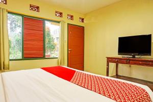 - une chambre avec un lit et une télévision à écran plat dans l'établissement Cunang Hill Hotel & Resort, à Bogor