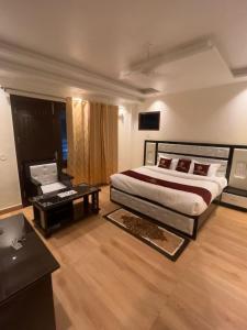 a bedroom with a bed and a desk with a laptop at The Divine Oak Golden Leaf in Katra