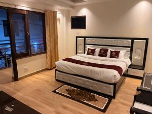 een slaapkamer met een groot bed en een televisie bij The Divine Oak Golden Leaf in Katra
