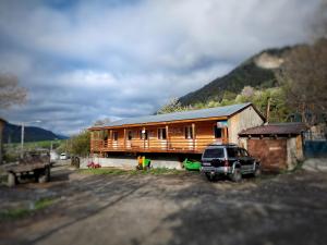 un'auto parcheggiata di fronte a una casa di legno di Girgola a Mestia