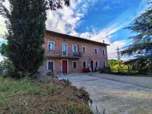 a brick house with a driveway in front of it at La Tomatica In Commedia in Mongardino