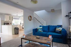 a living room with a blue couch and a table at SAXON ROAD - A 3 Bedroom House with Garden by Prestigious Stays - Includes Wifi, Netflix & Amazon Alexa in Sunbury Common