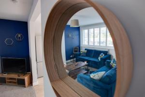 un soggiorno con pareti blu e specchio di SAXON ROAD - A 3 Bedroom House with Garden by Prestigious Stays - Includes Wifi, Netflix & Amazon Alexa a Sunbury Common