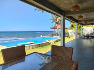 a patio with a view of a swimming pool and the ocean at Coco Blu Villa in Singaraja