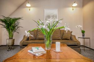 a living room with a vase of flowers on a table at White Lily Apartment in Klaipėda