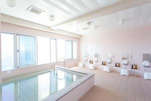 a large bathroom with a swimming pool and toilets at Hotel Peace Island Miyakojima Shiyakusho Tori in Miyako-jima