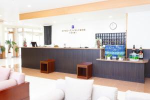 un vestíbulo con un bar con sofás blancos en Hotel Peace Island Miyakojima Shiyakusho Tori, en Isla Miyako