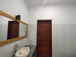 a bathroom with a sink and a mirror at Coco Blu Villa in Singaraja +28 photos