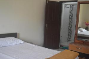 En eller flere senger på et rom på Lakshmi Kutteer Homestay