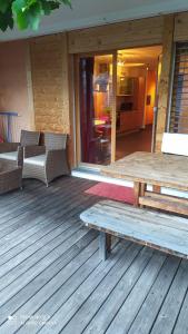 a wooden deck with a table and chairs on a house at Enzian 176 Al , Wohnung C3 in Tiefencastel