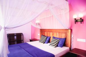 a bedroom with a bed with blue and white pillows at Nature Walk Ella in Ella