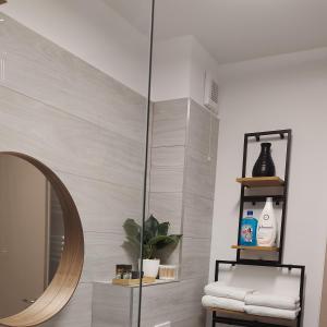 een badkamer met een spiegel en een spiegelplank bij DiaCos in Mamaia Nord – Năvodari